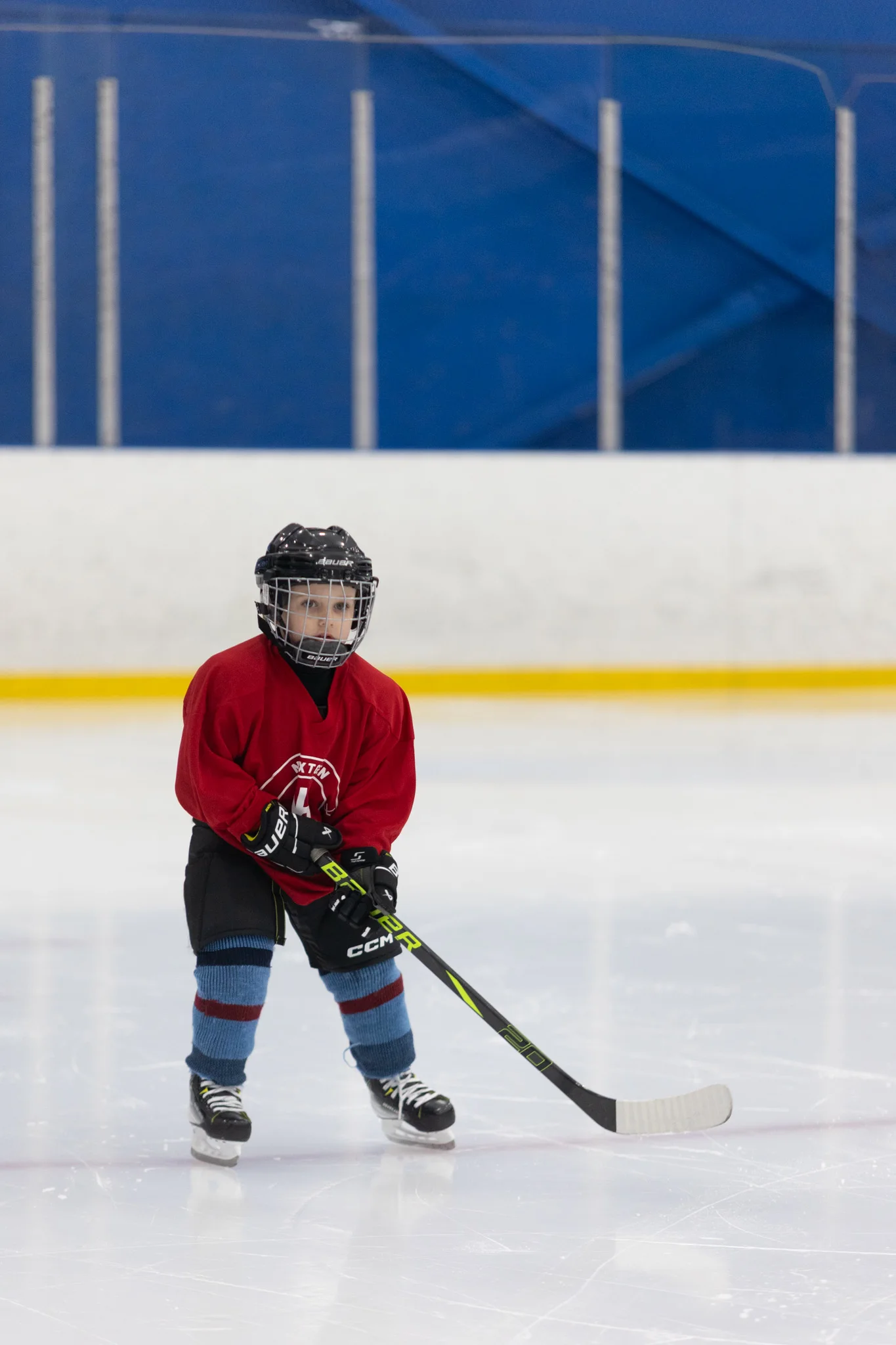 A young NextGen Hockey School player in a red jersey being evaluated on the ice at an ID Skate