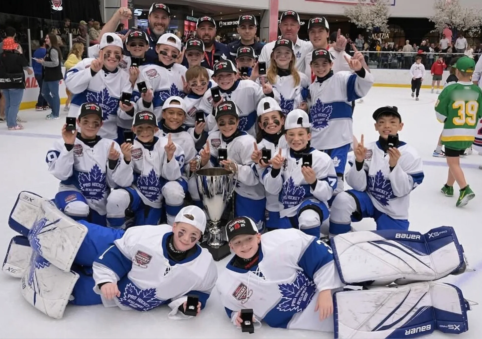 The NextGen Hockey School spring team together on the ice with their coaching staff